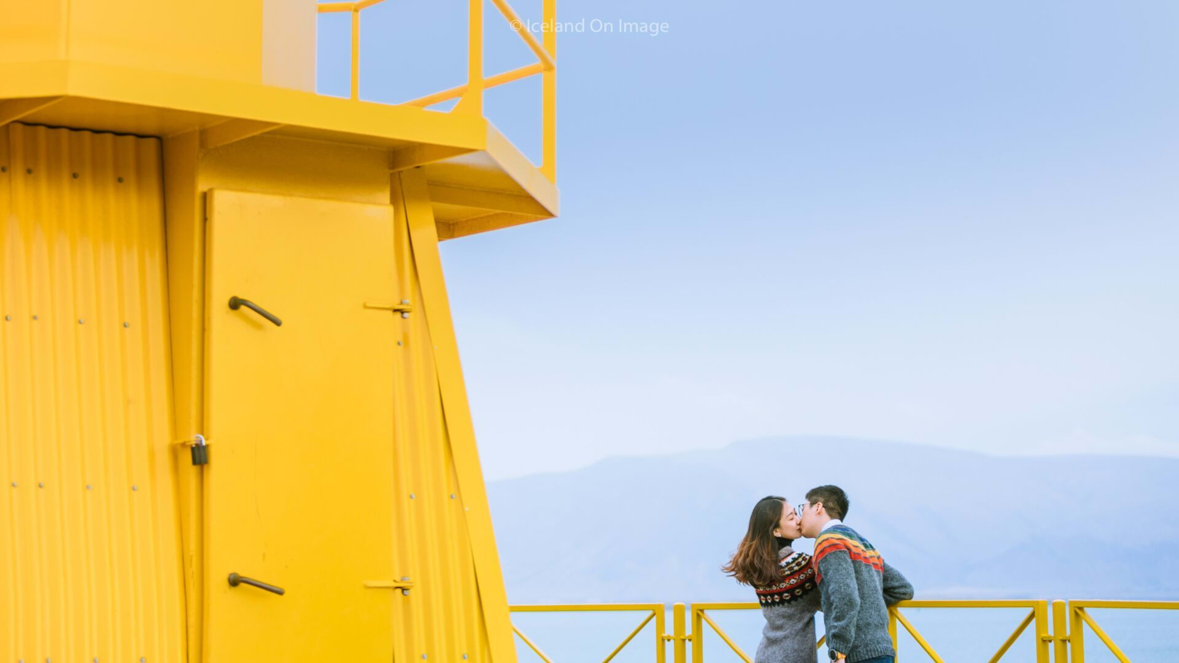 couple kiss at yellow beacon tower at reykjanes