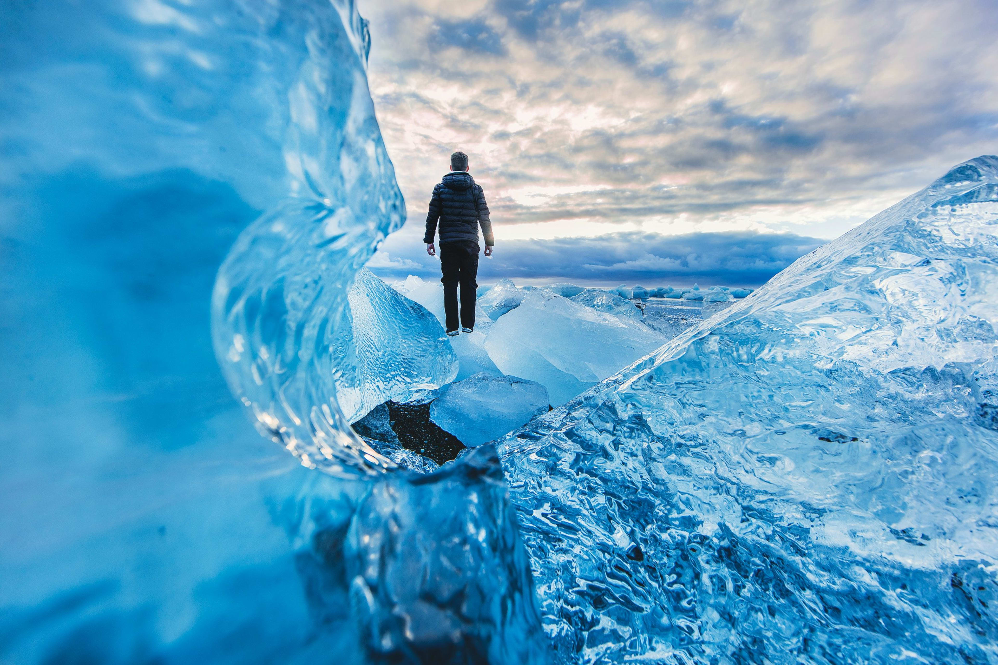 man on the great blue ice cave in south iceland
