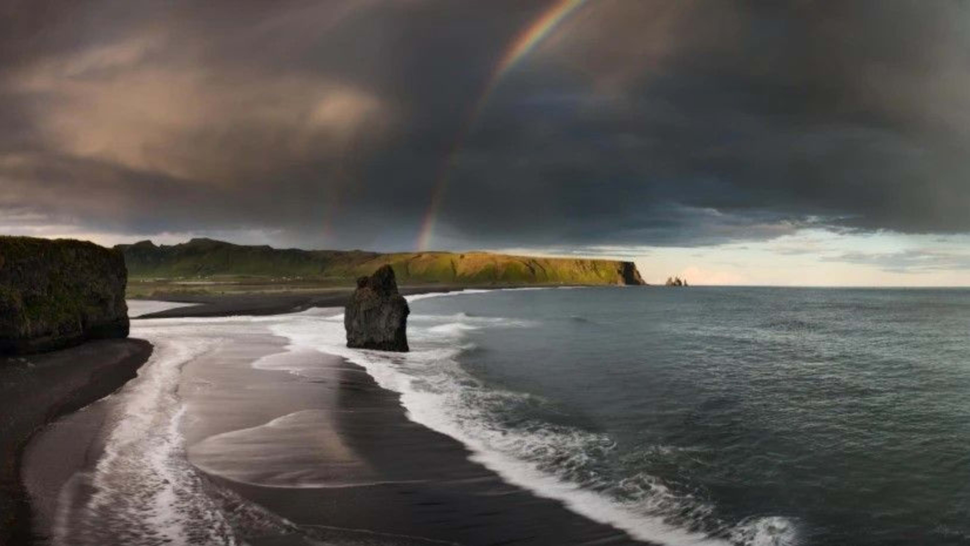 reynisfjara black sand beach with rainbow