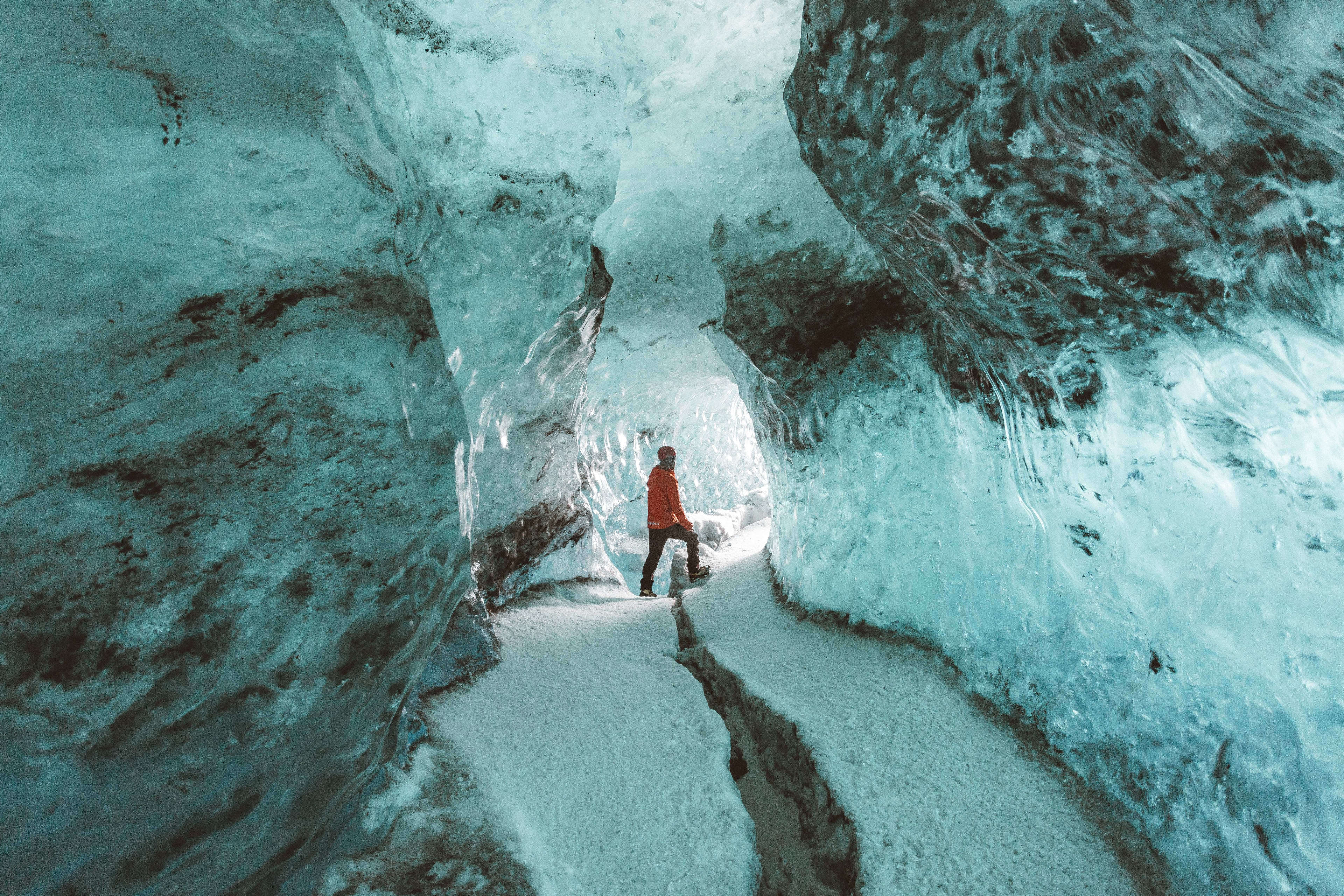 man exploring the blue ice cave