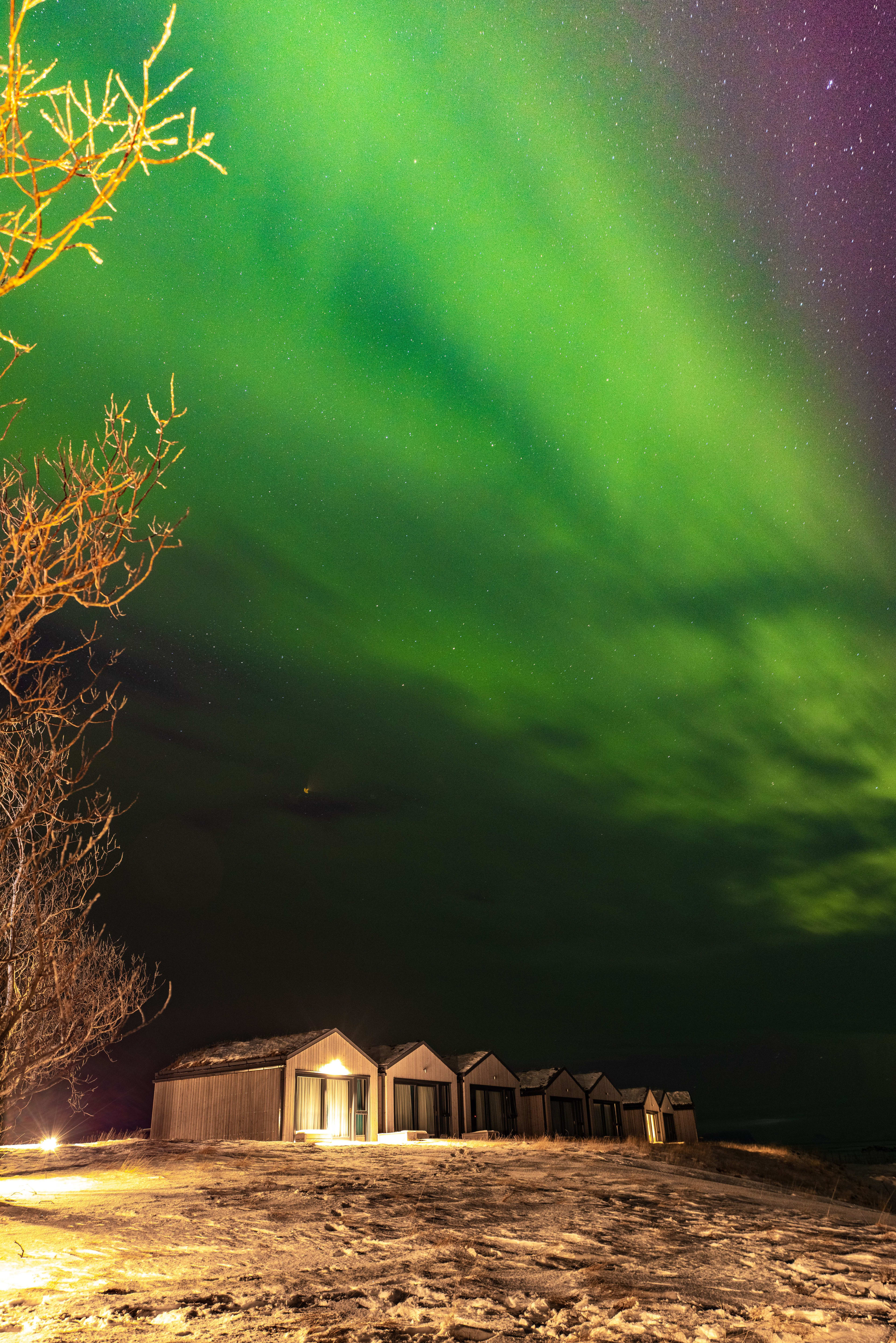 distant view of magma hotel under the northern lights