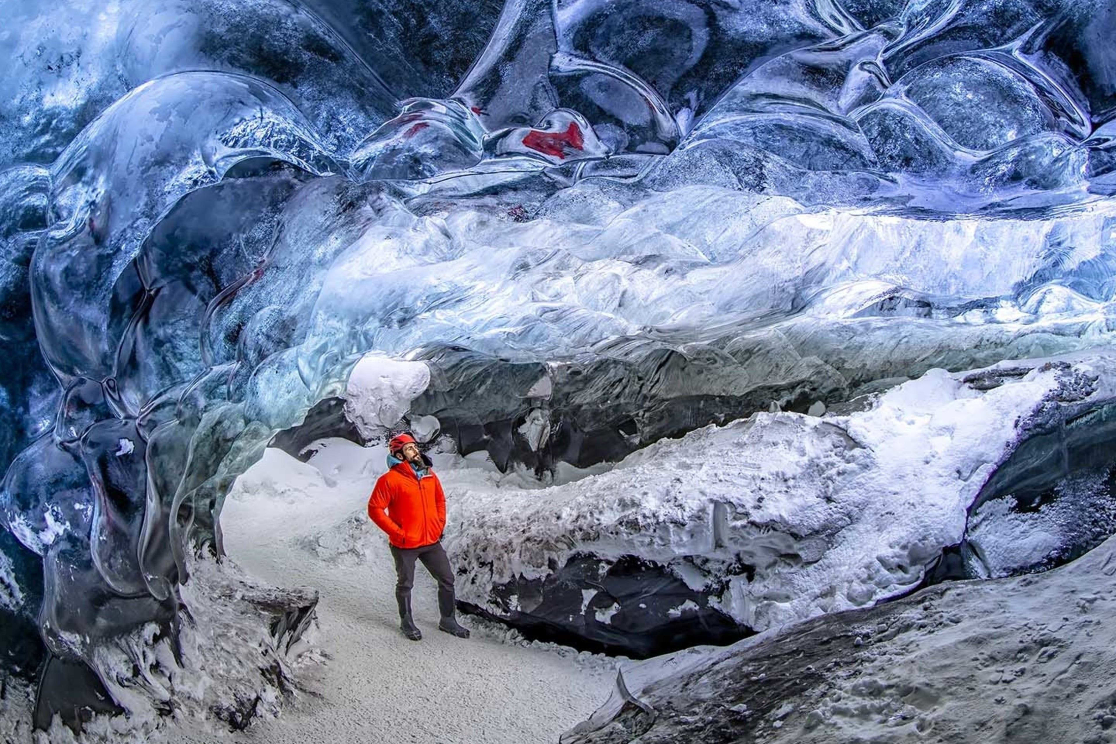 man visiting blue ice cave