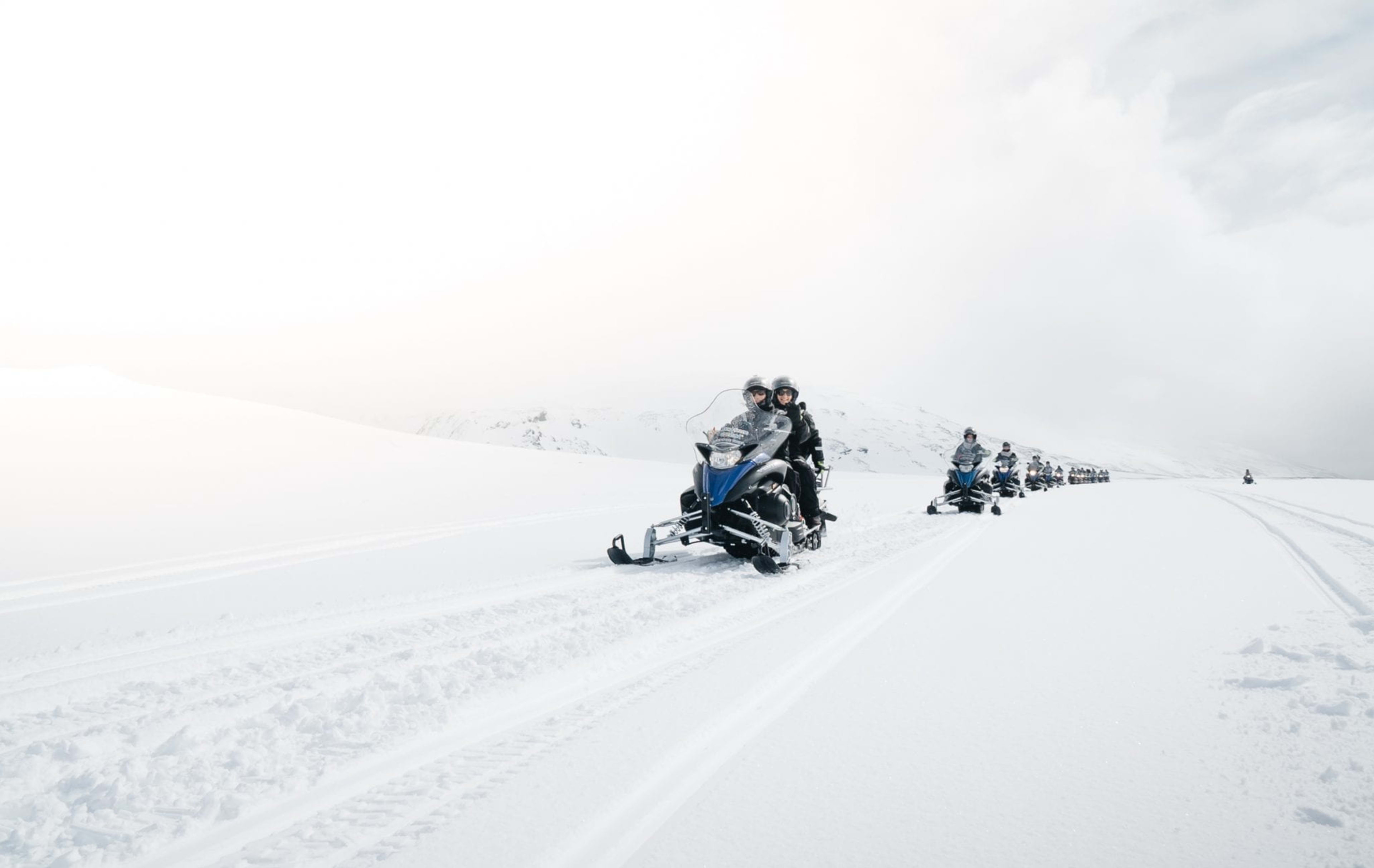 Snowmobiles speeding across the glacier