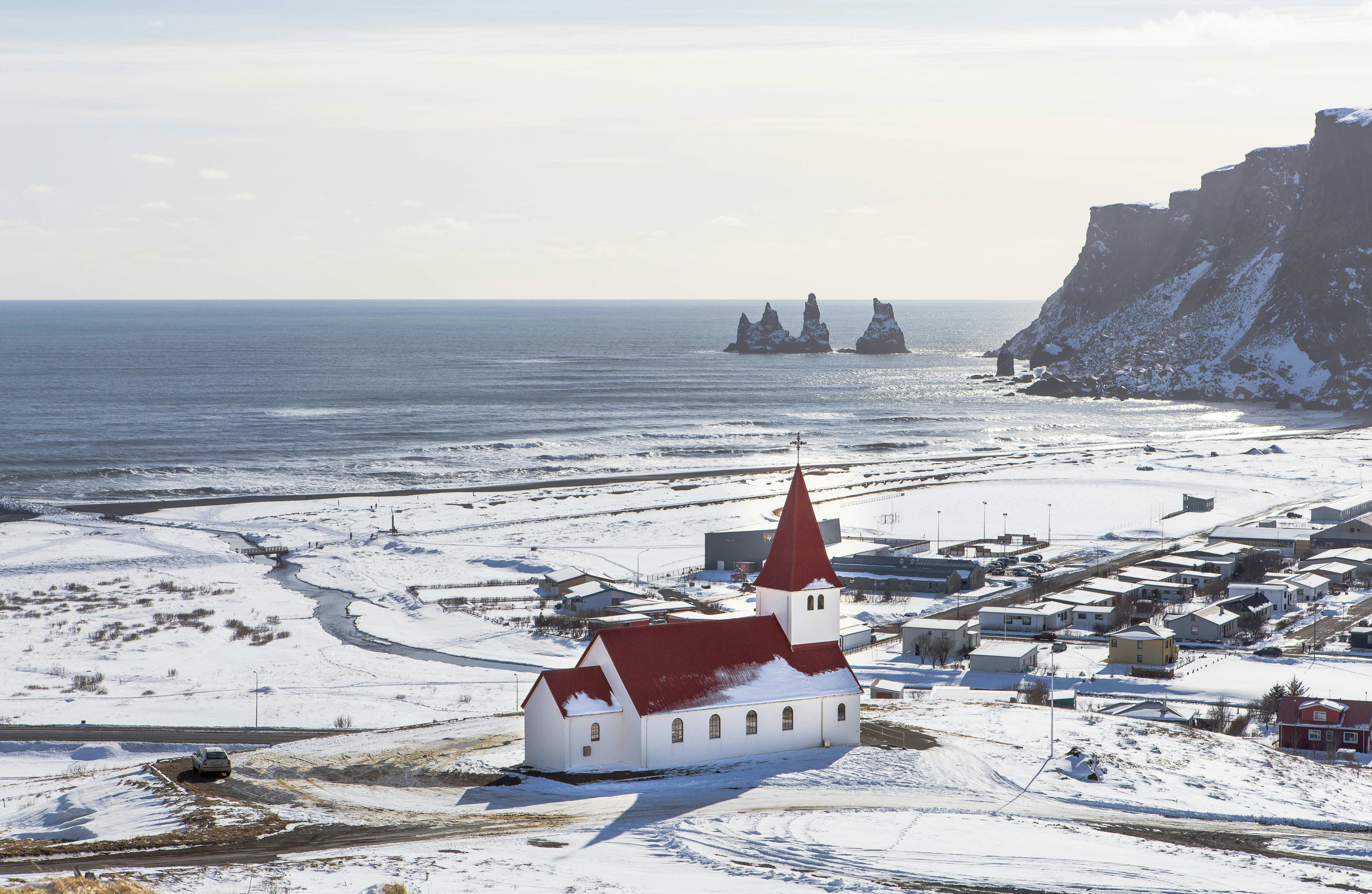 snow-covered vik town with red church of iceland