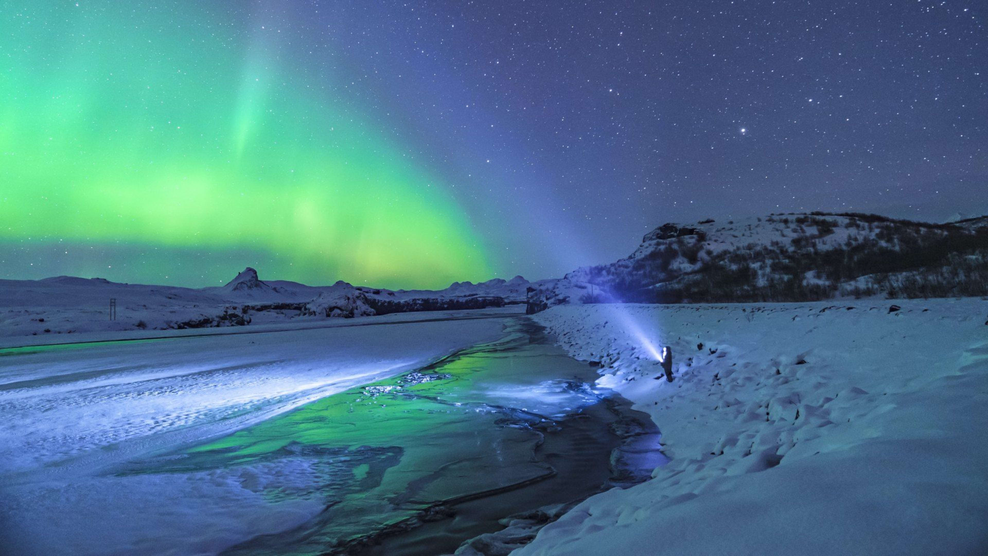 northern lights iceland person with torch